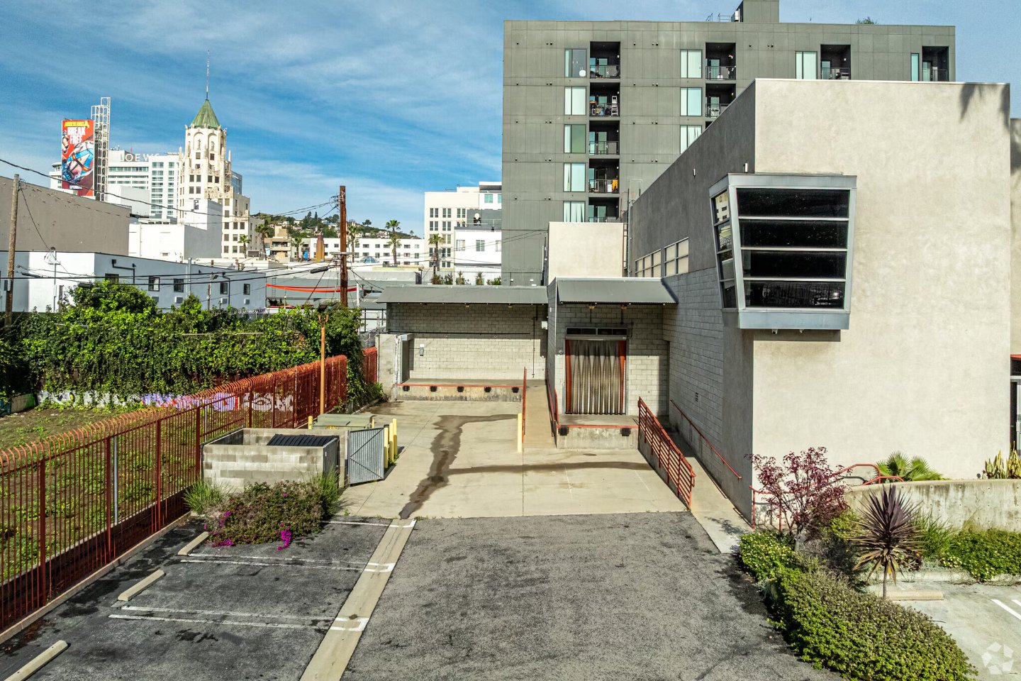 Selma House rear loading area with a roll-up loading door and dock-high bay, with the Hollywood skyline beyond