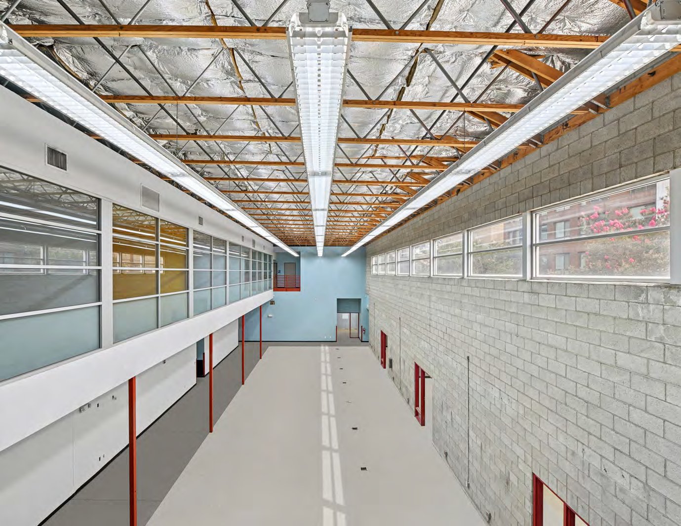 Long open floor plate with exposed steel roof trusses and clerestory glazing